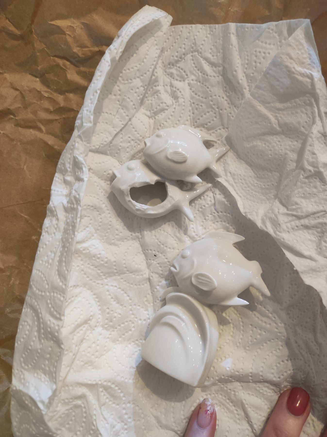 Die Figur in zwei Teilen vor der Reparatur, eine Flosse fehlte