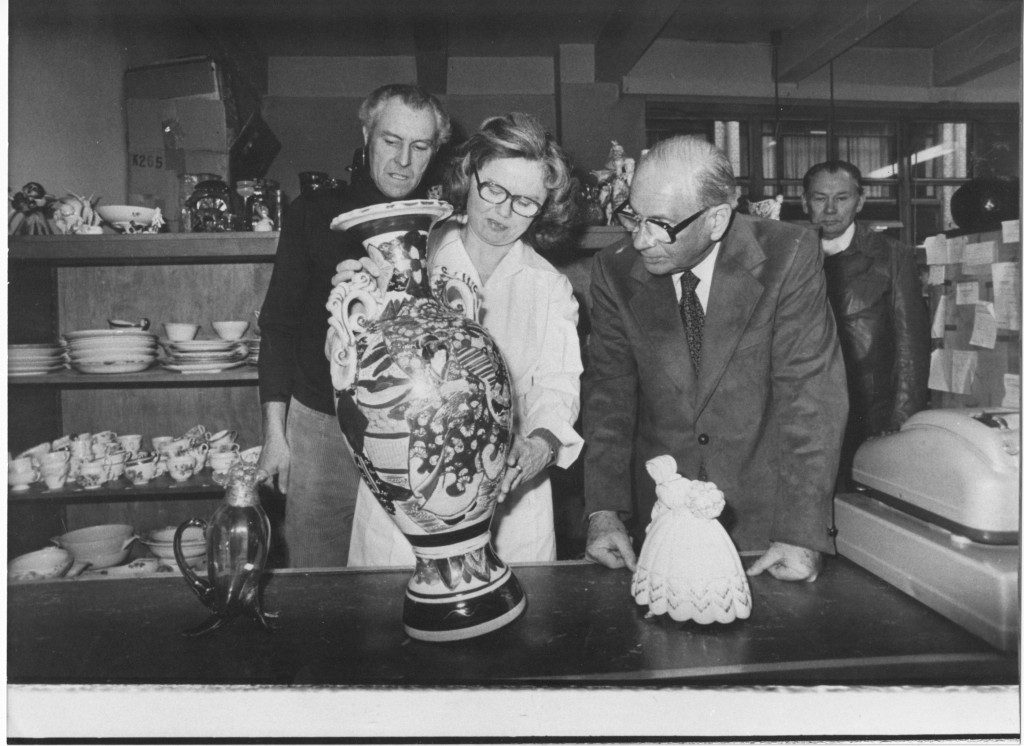Historische Aufnahme: drei Personen betrachten eine große Vase im Laden der Porzellan-Klinik