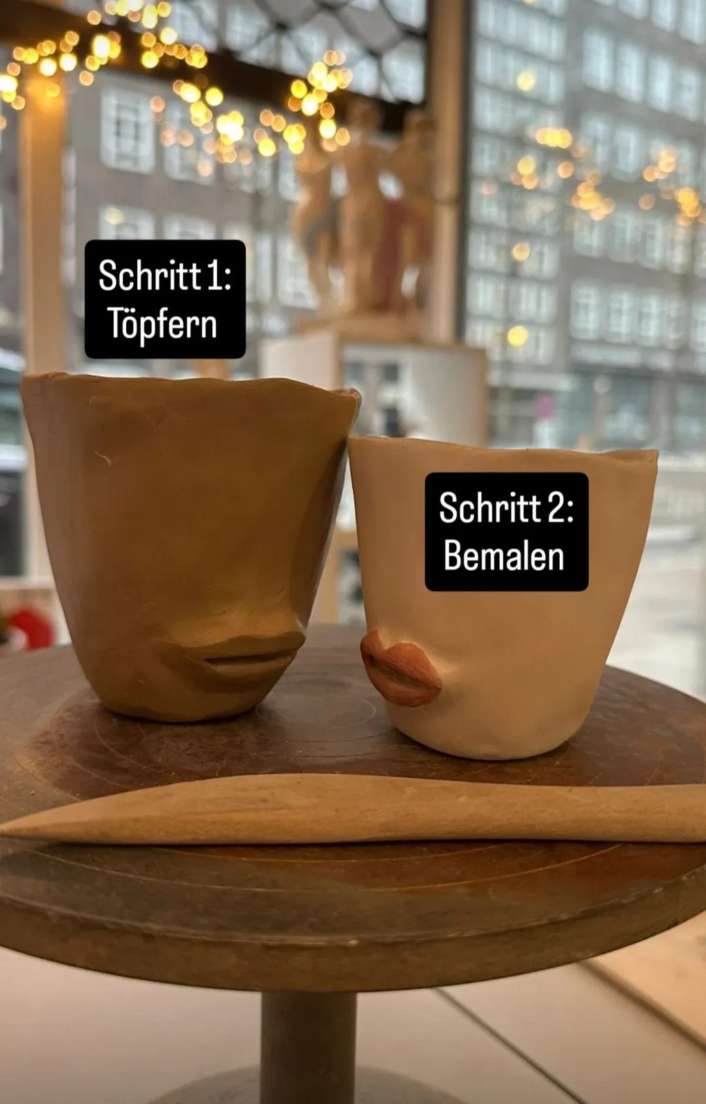 Zwei handgeformte Becher aus Ton, noch ungebrannt, auf dem Werktisch