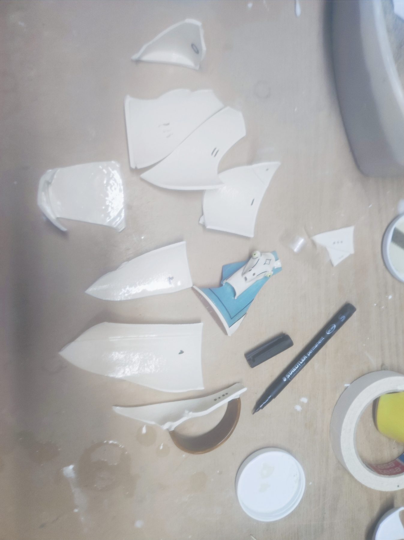 Die Scherben der Tasse aus Jingdezhen mit Pferdekopf-Motiv auf dem Werktisch